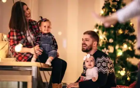a man and woman sitting on a table with two children