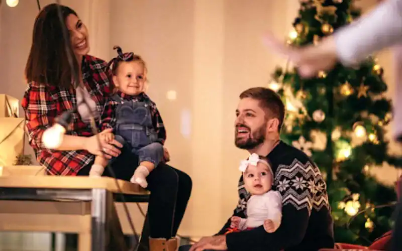 a man and woman sitting on a table with two children
