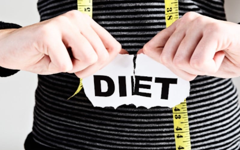 a person tearing a piece of paper with a tape measure around her chest