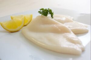 a plate of food with lemon wedges