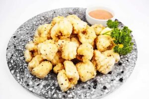 a plate of fried cauliflower with sauce