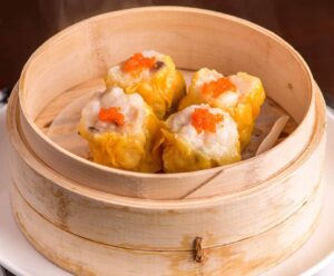 a round wooden basket with food in it