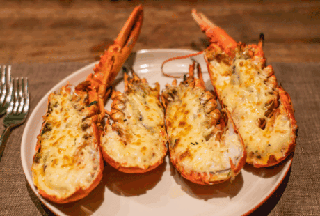 a plate of lobster tails with cheese on it