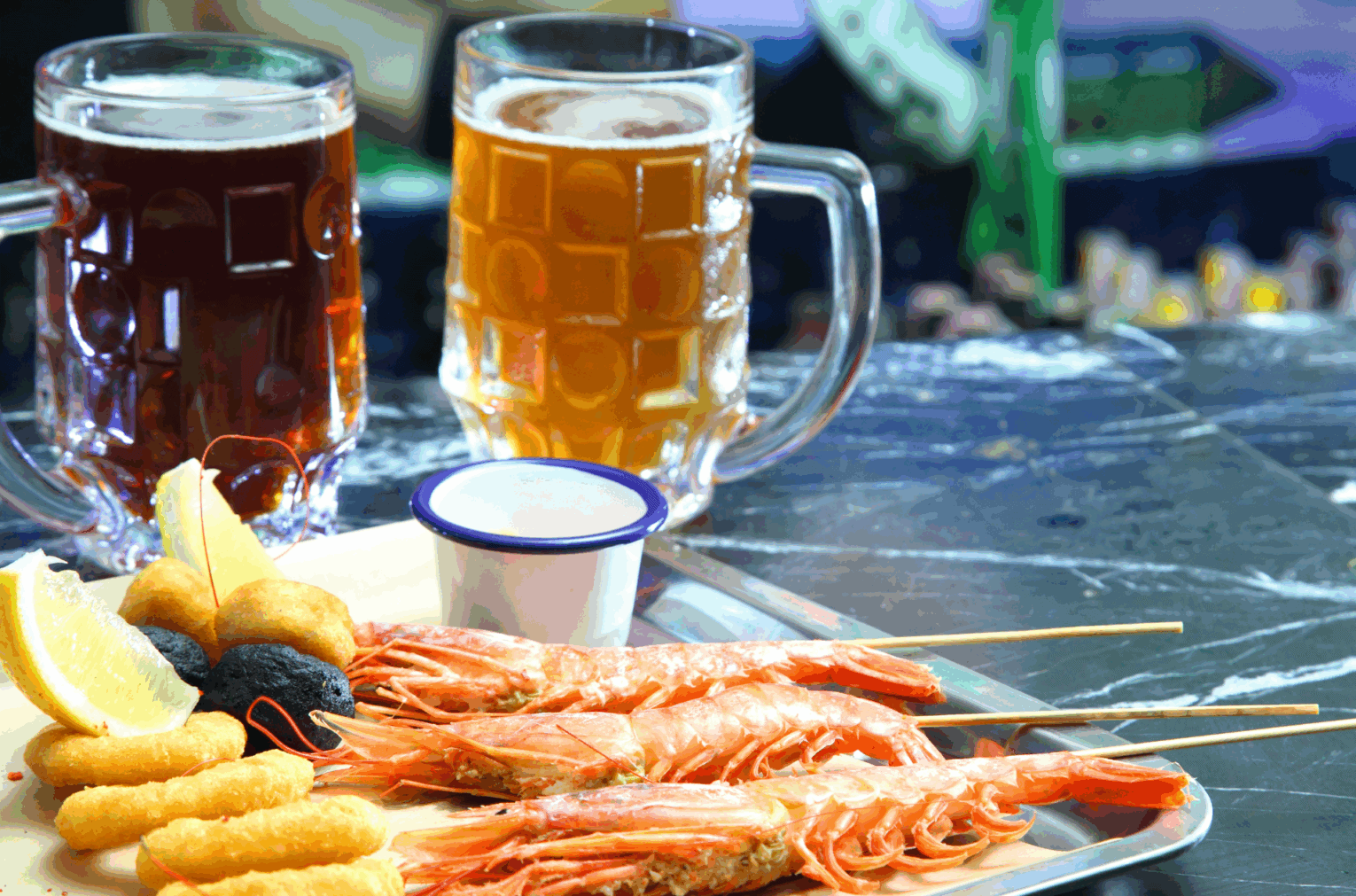 a plate of food with two glasses of beer